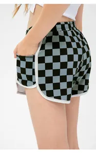 Detail of girls' checkered sports shorts with elastic waist and white contrast piping