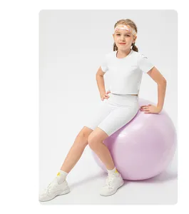 Detailed view of girls elastic white cycling shorts and crop top on a yoga ball