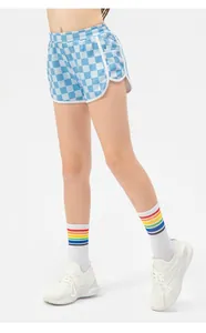 Detail of girls checkerboard sports shorts with elastic waist and white piping trim