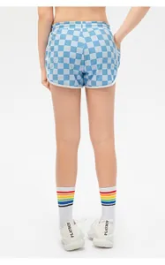 Detailed back view of checkered girls' sports shorts with elastic waist and white piping