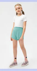 Detail view of mint green high-waisted sports shorts and white cropped top for active girls