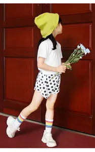 Detail of girl's summer outfit with white tee and black white polka dot shorts set
