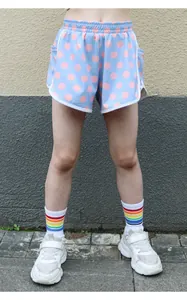 Close-up of light blue girls' sports shorts featuring pink polka dots and white trim