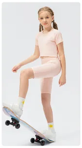 Detail of girls' light pink yoga set featuring breathable short sleeve top and tight shorts