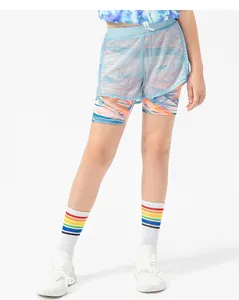 Detail of girls' 2-in-1 sports shorts with blue mesh layer and colorful abstract print