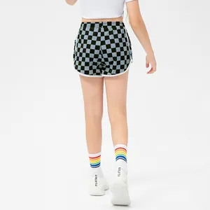 Girls' checkerboard sports shorts with elastic waist and white piping, back view on model