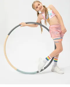 Girls activewear detail showing pink layered shorts and tie-dye vest with hula hoop