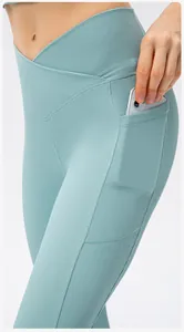 Detail of high waist criss-cross yoga pants with side pockets in ribbed blue fabric