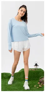 Detail of light blue sun protection long sleeve shirt with thumbholes and white shorts