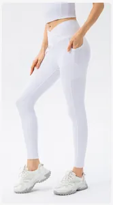 Detail view of white high-waisted yoga pants with v-cross waistband and side pocket
