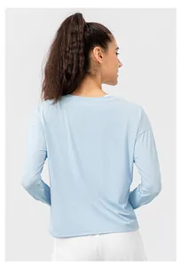 Back view of light blue women's long sleeve sun protection yoga top with drop shoulder