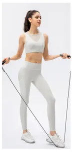 Détail du pantalon de yoga crème à poches latérales et brassière de sport en mesh