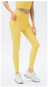 Detail of high-waist yellow ribbed yoga pants with crossover waist and side pocket