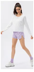 Detail of white sun protection top with thumb holes and purple athletic shorts