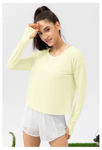 Detail of light yellow sun protection shirt with thumb holes and white mesh sports shorts
