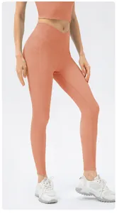 Detail of high waisted yoga leggings with cross waist design and side pockets in ribbed fabric