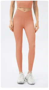 Detail of high waisted orange yoga set with ribbed fabric and cross waist design
