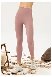 Detail of high-waisted seamless yoga leggings in dusty pink on a fitness model