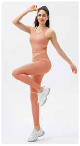 Dettaglio del set yoga a coste rosa corallo con reggiseno aderente e leggings a vita alta