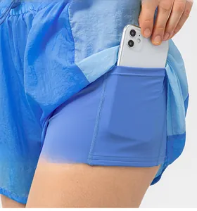 Dettaglio della tasca interna dei pantaloncini sportivi azzurri con uno smartphone
