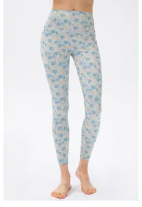 Detail der High-Waist Yoga-Leggings mit hellblauem Gänseblümchen-Print auf beigem Stoff