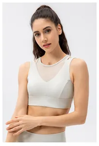 Detailed close-up of cream sports bra with mesh V-neck layering and high-stretch fabric
