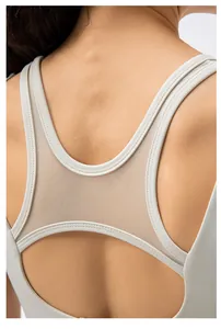 Close-up of breathable mesh panel and racerback design on light gray sports bra