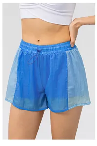 Dettaglio di pantaloncini sportivi larghi con design bicolore e vita elastica con coulisse