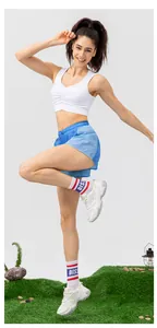 Dettaglio dei pantaloncini da yoga ampi e del top bianco con scollo a V su prato