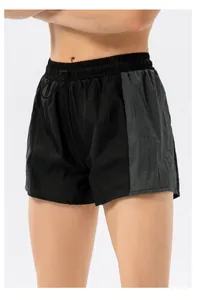 Dettaglio degli shorts sportivi da donna con vita elastica, coulisse nera e tessuto increspato