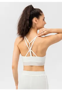 Detailed back view of white sports bra featuring criss-cross straps and mesh paneling