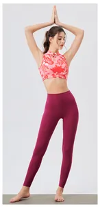 Two-piece yoga set featuring a floral high-neck crop top and burgundy leggings on a mat