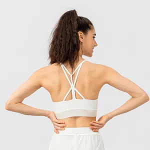 White yoga sports bra with criss-cross back straps and sheer mesh hem detail