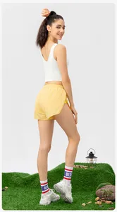 Detail view of a white high-impact sports vest with yellow running shorts on a female model