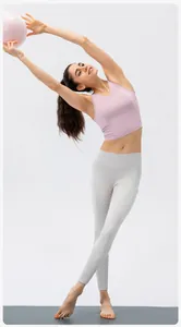 Side view of woman in light pink yoga top and grey leggings performing a stretch