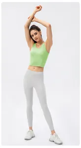 Close-up of a grass green fitted yoga tank top and grey leggings set for fitness