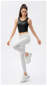 Full view of black high-impact sports crop top and white high-waist yoga pants on a model
