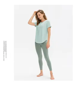 Dettaglio della maglietta yoga verde menta chiaro e leggings grigio-verde con tasca