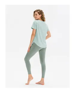 Dettaglio della maglietta da yoga verde menta con orlo curvo e tessuto leggero traspirante