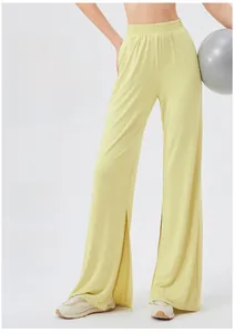 Detail view of high-waist split hem yoga pants with light yellow draped cooling fabric