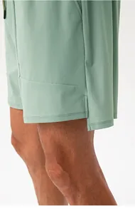 Dettaglio dei pantaloncini sportivi verdi traspiranti con spacco laterale da uomo