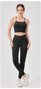 Detalle de conjunto de yoga negro con sujetador deportivo fruncido y mallas altas