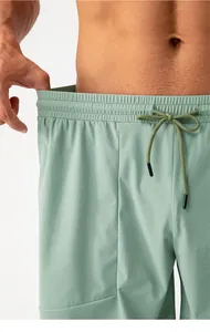 Dettaglio dei pantaloncini sportivi verde salvia da uomo con elastico in vita e coulisse