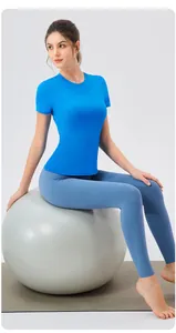 Ensemble t-shirt de yoga bleu ajusté et legging présenté sur un ballon de gym