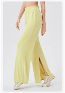 Detail view of high waisted wide leg pants featuring side slit and elastic waistband