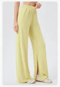 Detail showing the light yellow wide-leg pants with an elastic waist and side leg slits