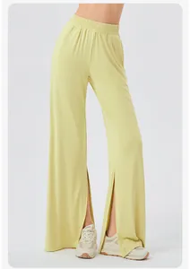 Detail of high waist light yellow wide leg yoga pants with side slit and draped fabric
