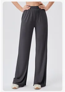 Detail of high waisted dark grey yoga pants showing elastic pleated waist and flowy fabric