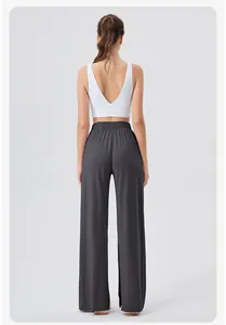 Detail of high-waist grey yoga pants with side slits and a white V-neck sports tank top
