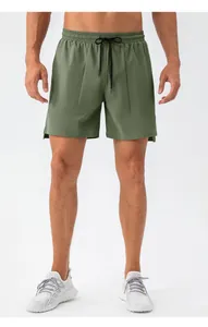 Detail of olive green athletic shorts featuring elastic waistband and adjustable drawstring